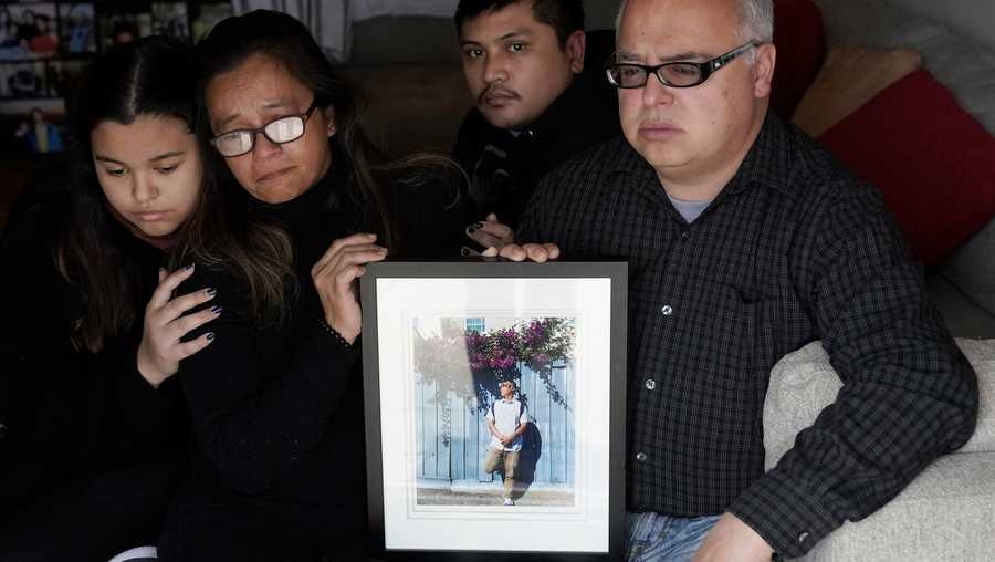 Cassandra Quinto-Collins, second from left, holds a photo of her son, Angelo Quinto, while sitting with daughter Bella Collins, left, son Andrei Quinto, center, and husband Robert Collins during an interview in Antioch, Calif., Tuesday, March 16, 2021. Angelo Quinto died three days after being restrained on Dec. 23, 2020, in police custody while having a mental health crisis.