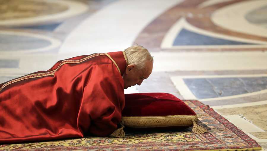 Pope Francis lies down in prayer during the Good Friday Passion of Christ Mass, inside St. Peter's Basilica, at the Vatican, Friday, March 30, 2018.