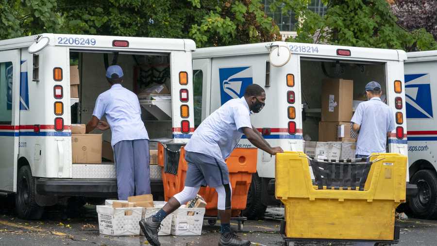 FILE - In this July 31, 2020, file photo, letter carriers load mail trucks for deliveries at a U.S. Postal Service facility in McLean, Va. The success of the 2020 presidential election could come down to a most unlikely government agency: the U.S. Postal Service.  (AP Photo/J. Scott Applewhite, File)