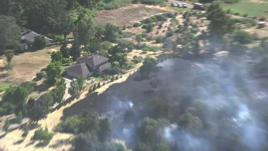 Crews contained a 3-acre grass fire Tuesday, June 13, 2017, before it spread to nearby homes.