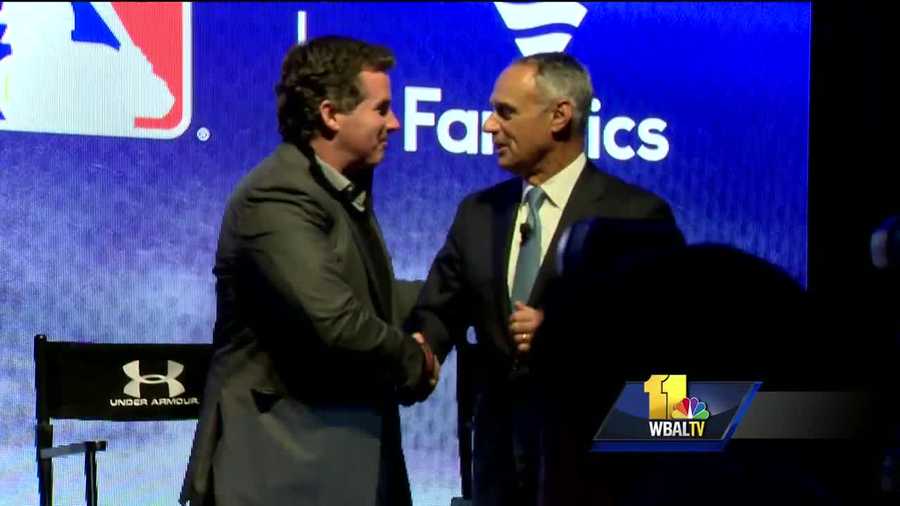 Under Armour founder and CEO Kevin Plank and MLB commissioner Rob Manfred shake hands after announcing a 10-year deal between their groups at baseball's winter meetings. 