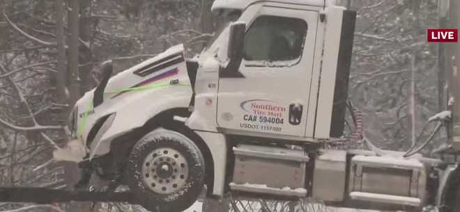 A tow truck prepares to remove a large truck that broke down on Interstate 80 at Rainbow Road.