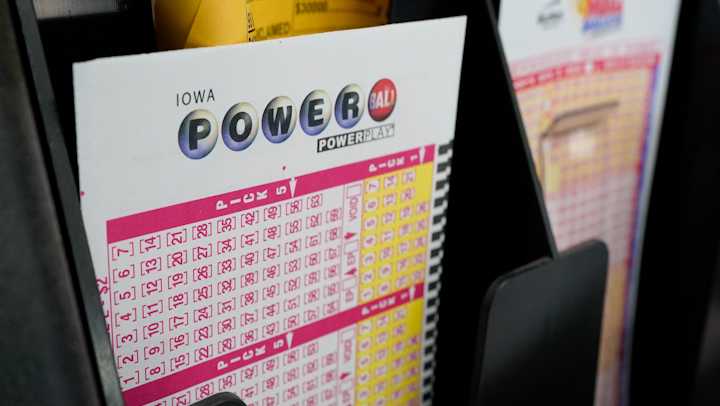 FILE - In this Jan. 12, 2021 file photo, blank forms for the Powerball lottery sit in a bin at a local grocery store, in Des Moines, Iowa. The giant Powerball jackpot has grown even bigger, with officials raising the estimated payout ahead of Saturday, Oct. 2, drawing.