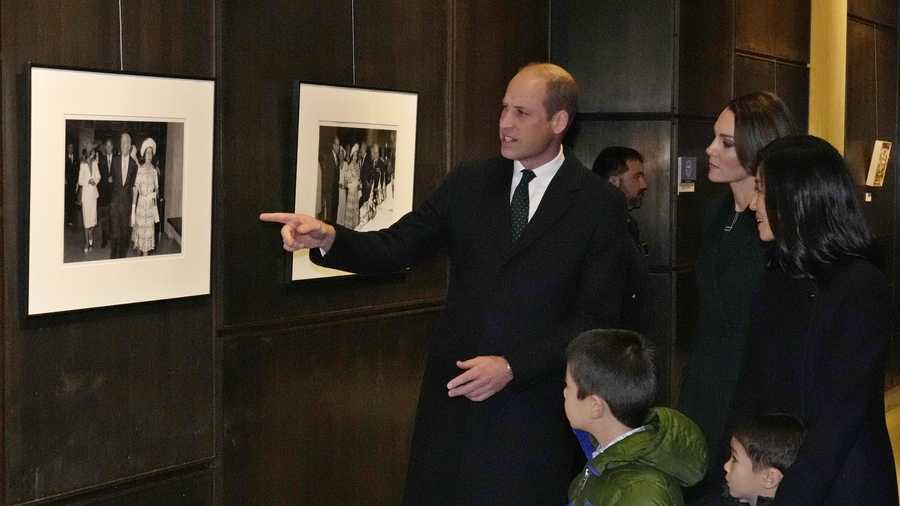 Britain's Prince William points to a 1970&apos;s photograph of Queen Elizabeth and then-Boston Mayor Kevin White with touring Boston City Hall with Kate, Princess of Wales, and Boston Mayor Michelle Wu and her family, Wednesday, Nov. 30, 2022, in Boston. (AP Photo/Charles Krupa, Pool)