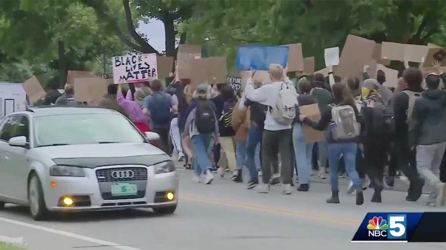 FILE - Protesters march in downtown Burlington on day six of a protest calling for the firing of three city police officers.