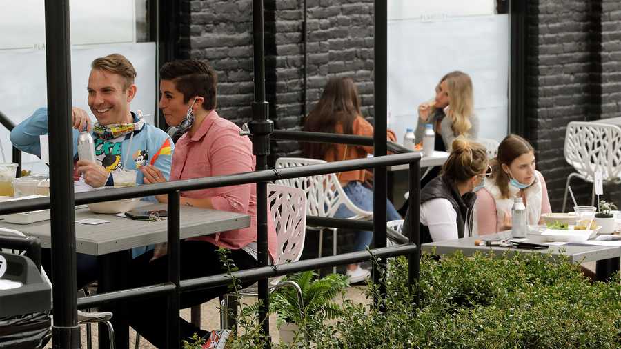 In this file photo, patrons lower their masks while dining in an outdoor seating area in Providence, R.I., Monday, May 18, 2020. (AP Photo)