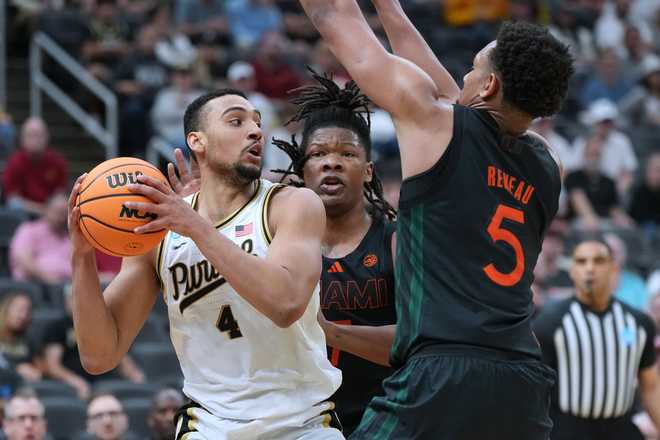 Purdue&amp;apos;s Trey Kaufman-Renn (4) looks to pass as Miami&amp;apos;s Shelton Henderson and Malik Reneau (5) defend during the first half in the second round of the NCAA college basketball tournament, Sunday, March 22, 2026, in St. Louis.