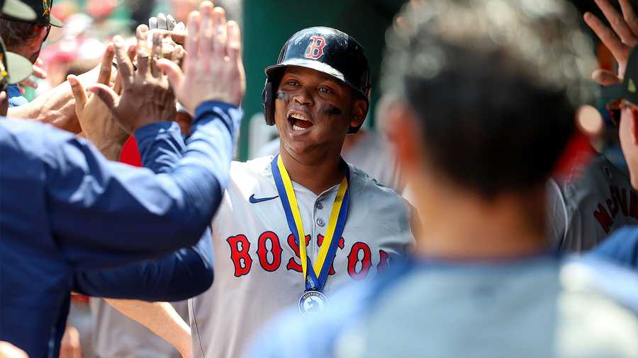 Rafael Devers of the Boston Red Sox is congratulated by teammates after hitting a two-run home run during the sixth inning against the St. Louis Cardinals at Busch Stadium on May 19, 2024 in St. Louis, Missouri.