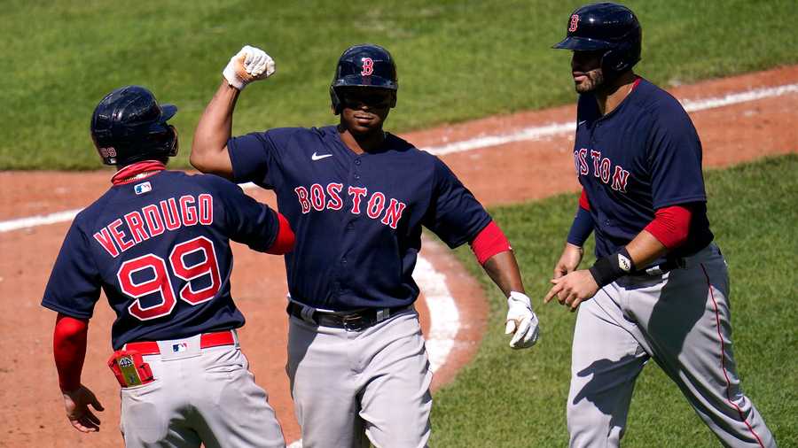 Boston Red Sox's Rafael Devers, center, celebrates his three-run home run with Alex Verdugo, left, and J.D. Martinez after he drove them home on a pitch by Baltimore Orioles pitcher Mac Sceroler during the fifth inning of a baseball game, Sunday, April 11, 2021, in Baltimore. (AP Photo)
