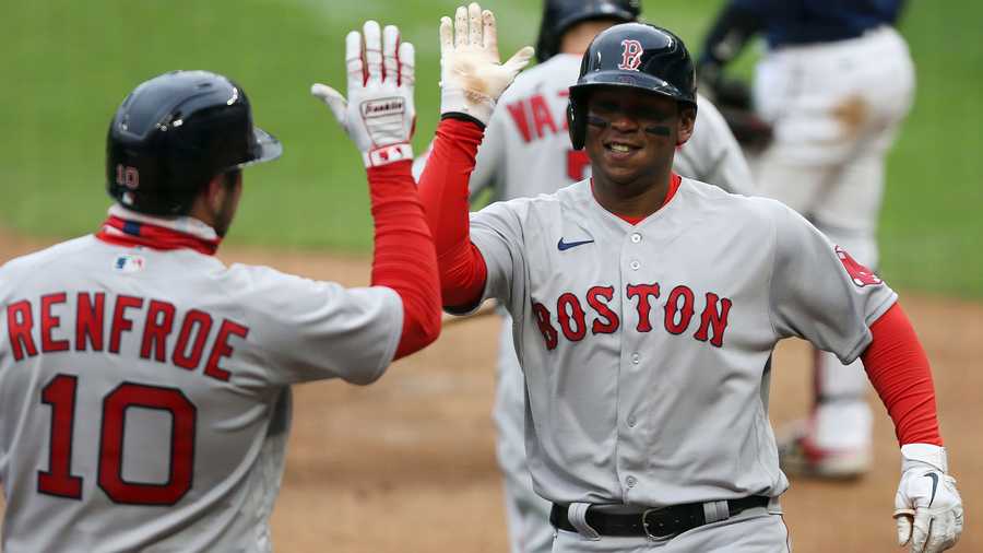 Boston Red Sox Rafael Devers (11) high fives teammate Boston Red Sox Hunter Renfroe (10) after hitting a home run against the Minnesota Twins during the ninth inning of a baseball game, Tuesday, April 13, 2021, in Minneapolis. Boston won 4-2. (AP Photo)