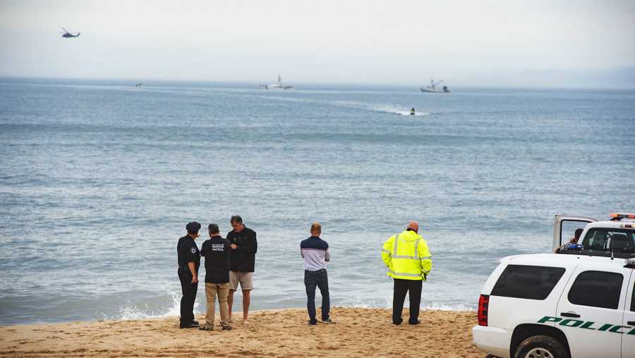 Members of the New York State park police look near the scene of a plane crash in the ocean off Indian Wells Beach in Amagansett, N.Y., Saturday, June 2, 2018.
