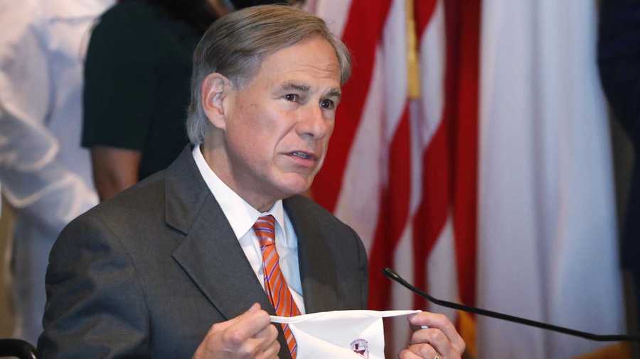 Texas Gov. Greg Abbott holds up mask as he talks about the importance of wearing face coverings to prevent the spread of COVID-19 during a news conference in Dallas, Thursday, Aug. 6, 2020. (AP Photo/LM Otero)