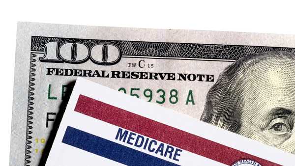 <p>A file image of a Medicare card on top of a $100 bill. </p>