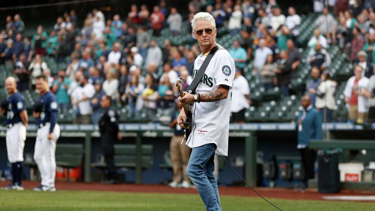 Mike McCready of the band Pearl Jam, poses for photos on the field after  performing the National Anthem before a baseball between the Chicago White  Sox and the Seattle Mariners on Friday