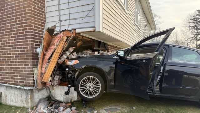 1 taken to hospital after car crashes into Mass. home
