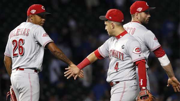 Cincinnati Reds' Raisel Iglesias (26) and Jose Iglesias (4) celebrate the Reds' 3-2 win over the Chicago Cubs in a baseball game Wednesday, Sept. 18, 2019, in Chicago. (AP Photo/Charles Rex Arbogast)
