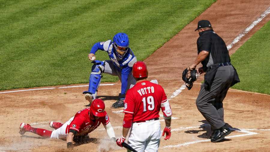 Cincinnati Reds&apos; Tyler Naquin, left, scores a run after teammate Nick Castellanos (not shown) hit a double in the first inning during a baseball game against the Chicago Cubs in Cincinnati on Saturday, May 1, 2021. (AP Photo/Jeff Dean)