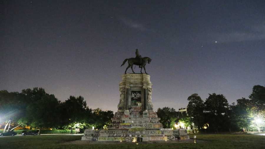 The moon and street lights illuminate the statue of Confederate General Robert E. Lee on Monument Avenue Friday June. 5, 2020, in Richmond, Va.