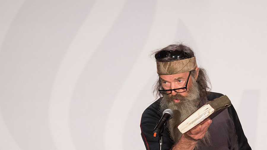 Reality TV&apos;s Duck Dynasty star Phil Robertson holds up his Bible during a campaign rally for Republican presidential candidate Ted Cruz.