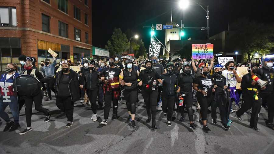Demonstrators march along a street in Rochester, N.Y., Friday, Sept. 4, 2020, during a protest over the death of Daniel Prude. Prude apparently stopped breathing as police in Rochester were restraining him in March 2020 and died when he was taken off life support a week later. (AP Photo/Adrian Kraus)