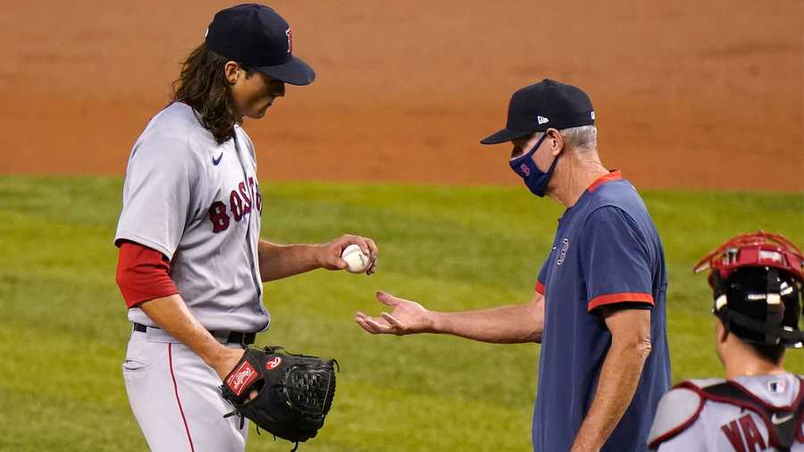 Boston Red Sox starting pitcher Mike Kickham, left, hands the ball to interim manager Ron Roenicke, right, as he is relieved during the third inning of a baseball game against the Miami Marlins, Wednesday, Sept. 16, 2020, in Miami. (AP Photo/Lynne Sladky)