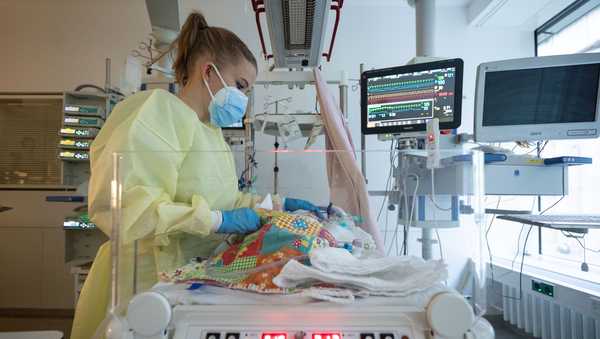 An intensive care nurse cares for a patient suffering from RSV who is being ventilated.