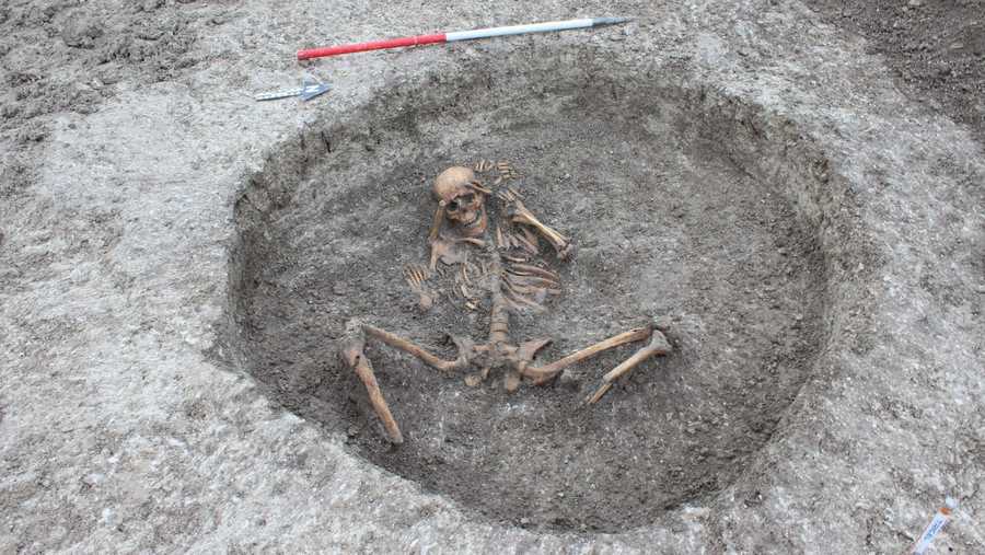 This is a photograph of a female skeleton buried with the feet cut off and placed by its side.