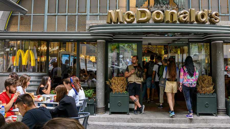 A handler and his falcon stand at the entrance of McDonald's fast food restaurant in Praça da Liberdade, a favorite spot for locals and tourists, to scare away pigeons that bother patrons sitting at sidewalk tables, on September 16, 2019 in Porto, Portugal.