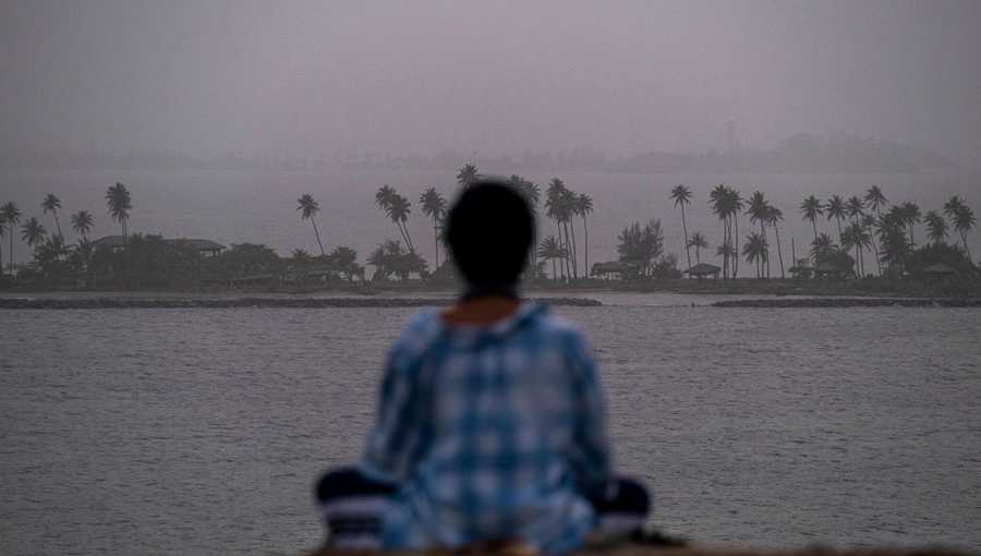 A woman meditates as a vast cloud of Sahara dust is blanketing the city of San Juan, Puerto Rico on June 22, 2020.