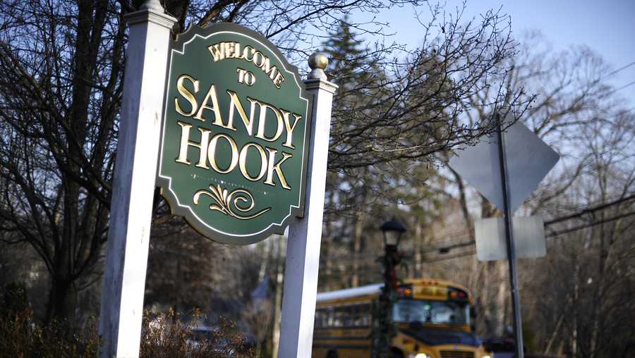 A bus drives past a sign reading Welcome to Sandy Hook, Wednesday, Dec. 4, 2013, in Newtown, Conn.