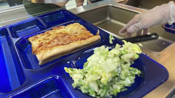 A student lunch of pizza and caesar salad is placed on a tray at the Albert D. Lawton Intermediate School, in Essex Junction, Vt., Thursday, June 9, 2022.