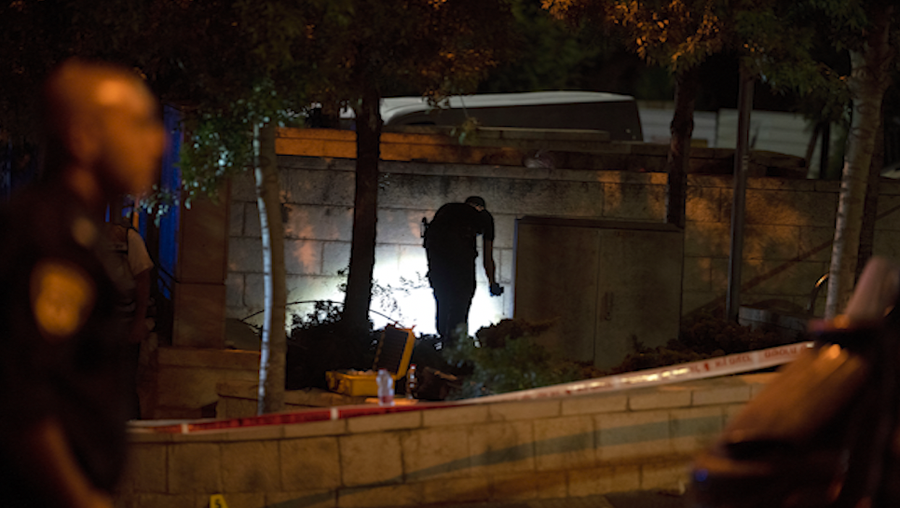 An Israeli police crime scene investigator works at the scene of a shooting attack that wounded several Israelis near the Old City of Jerusalem, early Sunday, Aug. 14, 2022.