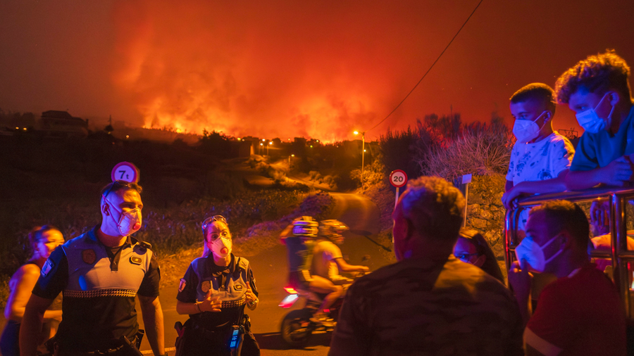 Residents try to reach their houses in Benijos village as police block the area as a wildfire advances in La Orotava in Tenerife, Canary Islands, Spain on Aug. 19, 2023.