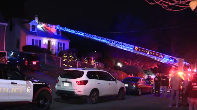 Woman hanging from window of burning home, rescued by firefighters