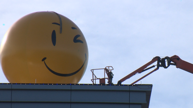 Walmart hoists 16-foot smiley face sculpture on the roof of Sparky