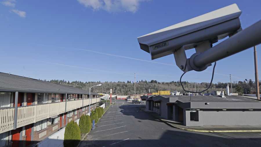 FILE - In this March 4, 2020 file photo, a security camera is shown on the second floor of a row of rooms at a motel in Kent, Wash.  Hackers aiming to call attention to the dangers of mass surveillance said they were able to peer into hospitals, schools, factories, jails and corporate offices after they broke into the systems of a security-camera startup.