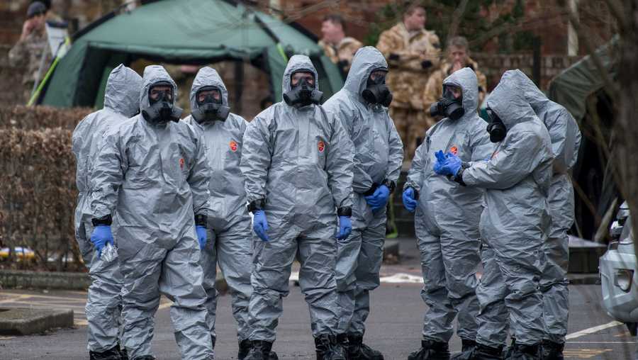 Military personnel wearing protective suits remove a police car and other vehicles from a public car park as they continue investigations into the poisoning of Sergei Skripal on March 11, 2018 in Salisbury, England.