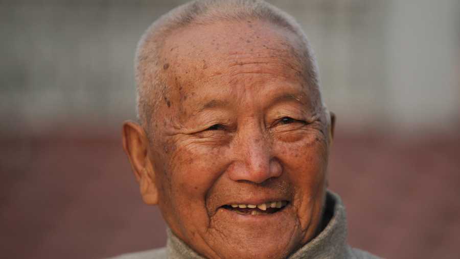 In this April 12, 2017 file photo, Nepalese mountain climber Min Bahadur Sherchan, 85, smiles as he finishes his morning yoga workout at his residence in Kathmandu, Nepal. Officials say Sherchan who was attempting to scale Mount Everest to regain his title as the oldest person to scale the world’s highest peak has died at the base camp on Saturday, May 6, but was not clear about the cause of the death. 
