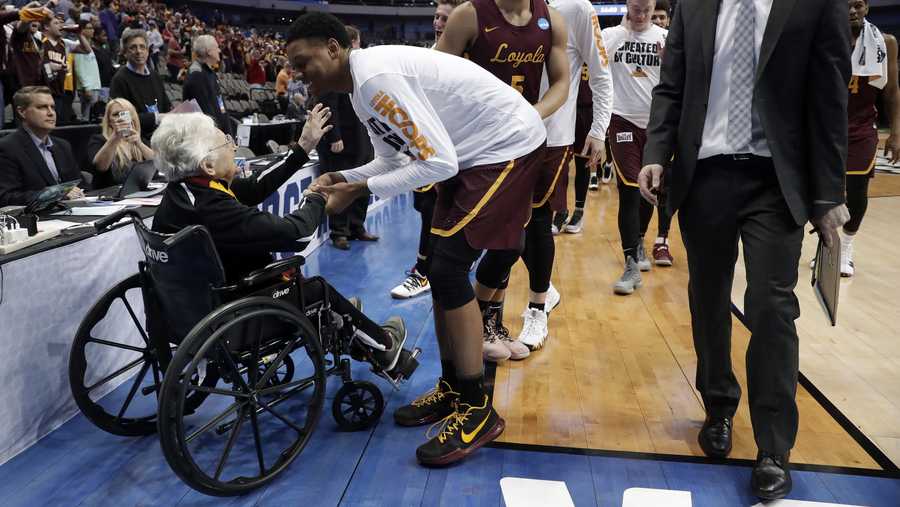 Sister Jean Dolores Schmidt, left, greets the Loyola-Chicago basketball team as they walk off the court after their win over Miami in a first-round game at the NCAA college basketball tournament in Dallas, Thursday, March 15, 2018.
