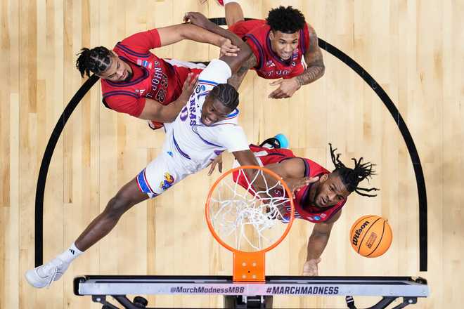 St. John&amp;apos;s forward Zuby Ejiofor, right, and Kansas forward Flory Bidunga (40) vie for a reobund during the first half of a game in the second round of the NCAA college basketball tournament Sunday, March 22, 2026, in San Diego.