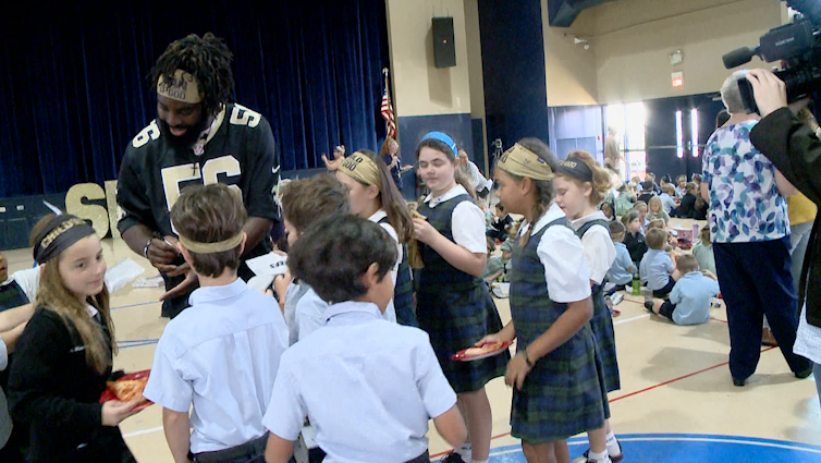 Saints' Demario Davis surprises students with 'Child of God' headbands