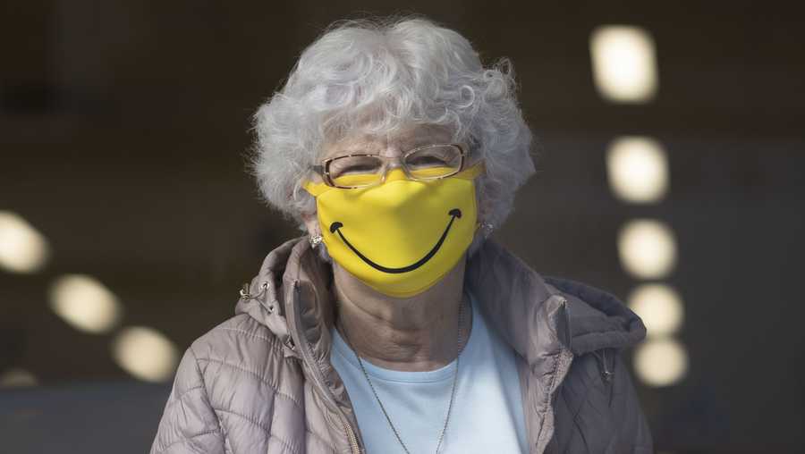 A woman smiles while wearing a novelty face mask in a shop on October 1, 2020 in Barry, Wales.