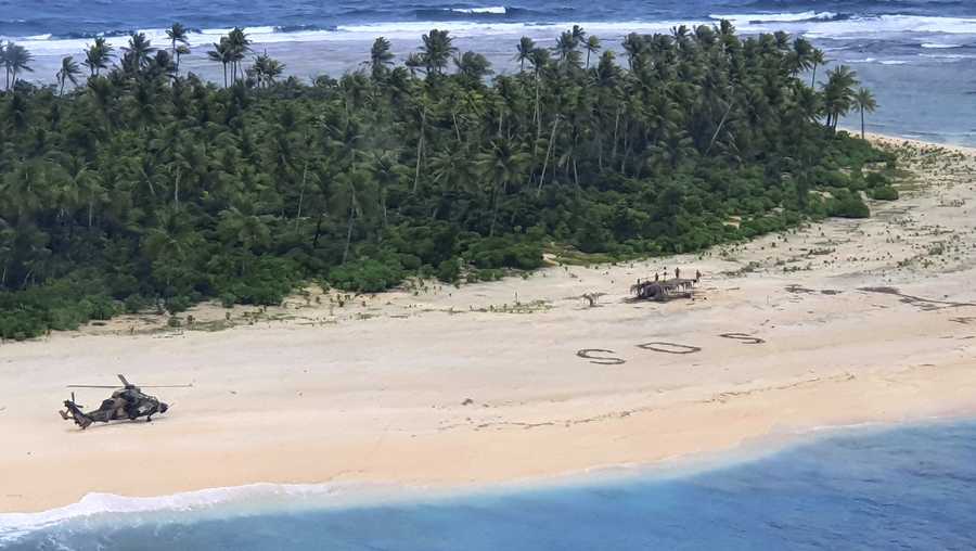 In this photo provided by the Australian Defence Force, an Australian Army helicopter lands on Pikelot Island in the Federated States of Micronesia, where three men were found, Sunday, Aug. 2, 2020, safe and healthy after missing for three days. The men were missing in the Micronesia archipelago east of the Philippines for nearly three days when their "SOS" sign was spotted by searchers on Australian and U.S. aircraft, the Australian defense department said. (Australian Defence Force via AP)