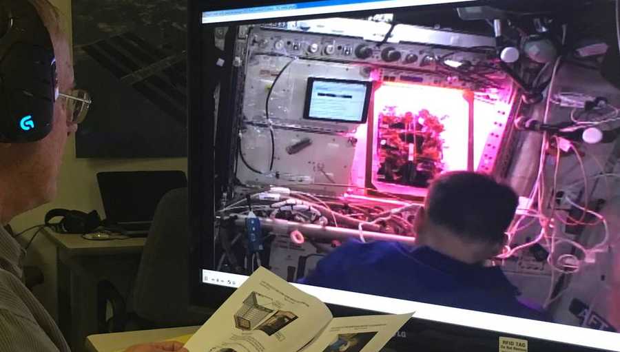 Charles Spern, a Veggie project engineer with the Engineering Services Contract, relays messages from the Kennedy Space Center Veggie team to assist the crew during harvest.