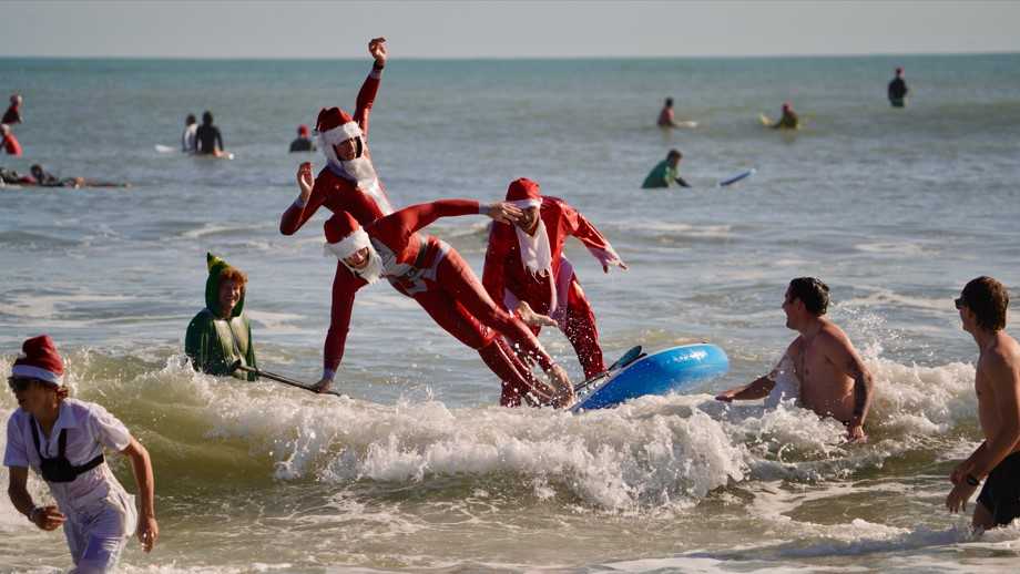 Dozens of Santas take over Florida beach in annual surfing event