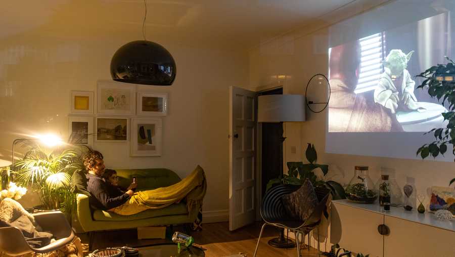 Andrew and his son Hector are seen watching Star Wars inside their home using a projector on April 04, 2020 in London, England. People have been forced to stay at home due to social distancing measures that have been put in place to slow the spread of the Coronavirus, Covid-19 Pandemic. 