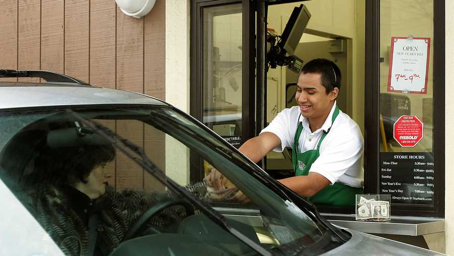 Starbucks worker Freddie Arteaga assists a customer with her drink order at a Starbucks drive-thru December 28, 2005 in Wheeling, Illinois. Starbucks is investing in the drive-thru market for coffee drinkers on the go.