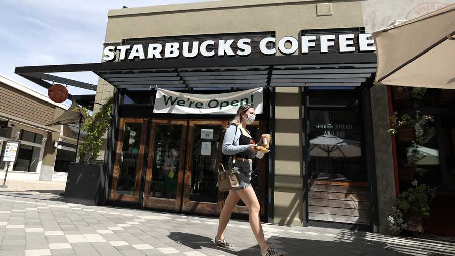 A masked customer walks by a Starbucks Coffee store on June 10, 2020 in Corte Madera, California.