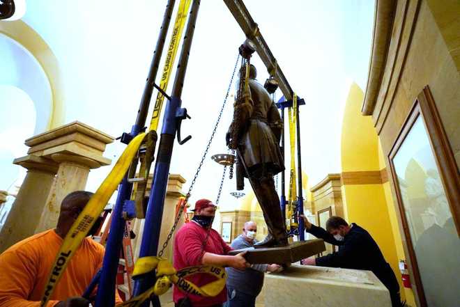 FILE - This Monday, Dec. 21, 2020 photo provided by the Office of the Governor of Virginia shows workers removing a statue of Confederate Gen. Robert E. Lee from the National Statuary Hall Collection in Washington.