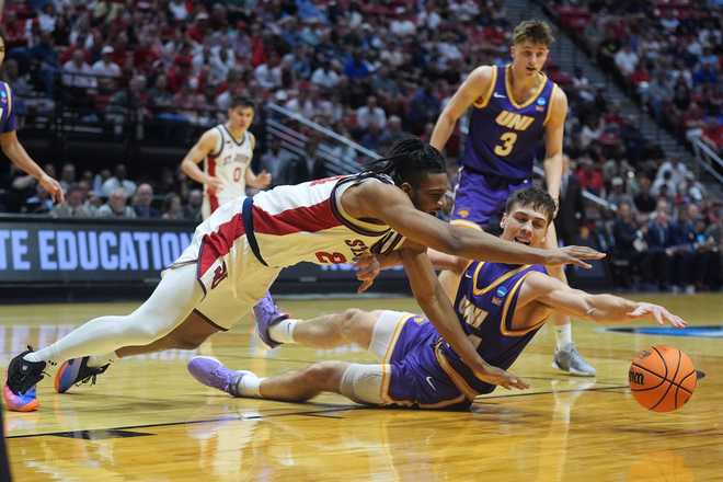 Northern Iowa forward Tristan Smith, below right, and St. John's forward Zuby Ejiofor battle for a loose ball during the first half in the first round of the NCAA college basketball tournament Friday, March 20, 2026, in San Diego.